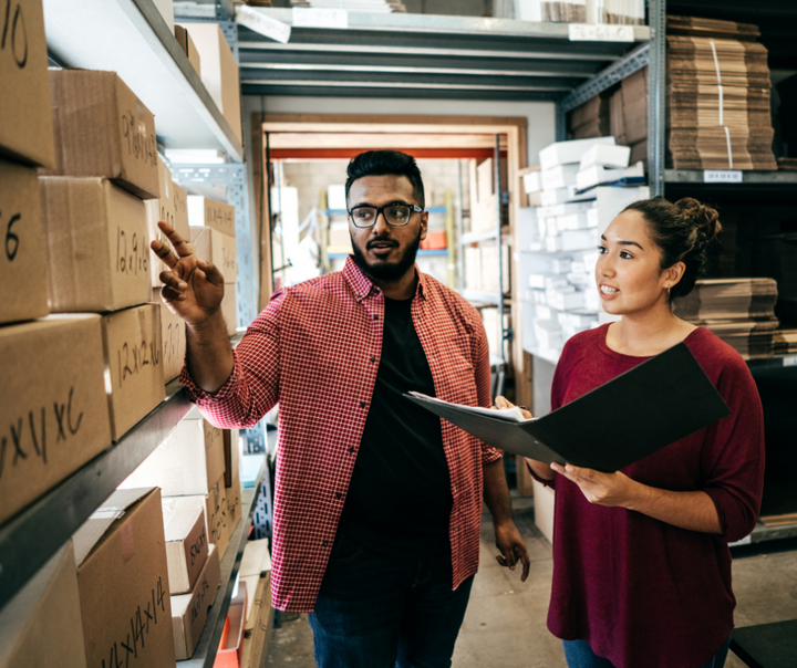 Business owners reviewing inventory and operations while planning how to reinvest capital in your business