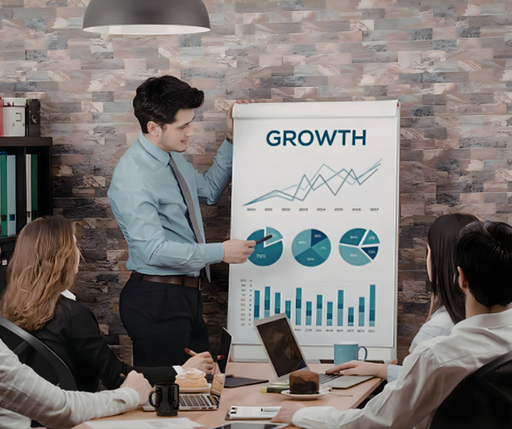 Business professional presenting small business financial metrics and growth charts to a team during a strategy meeting