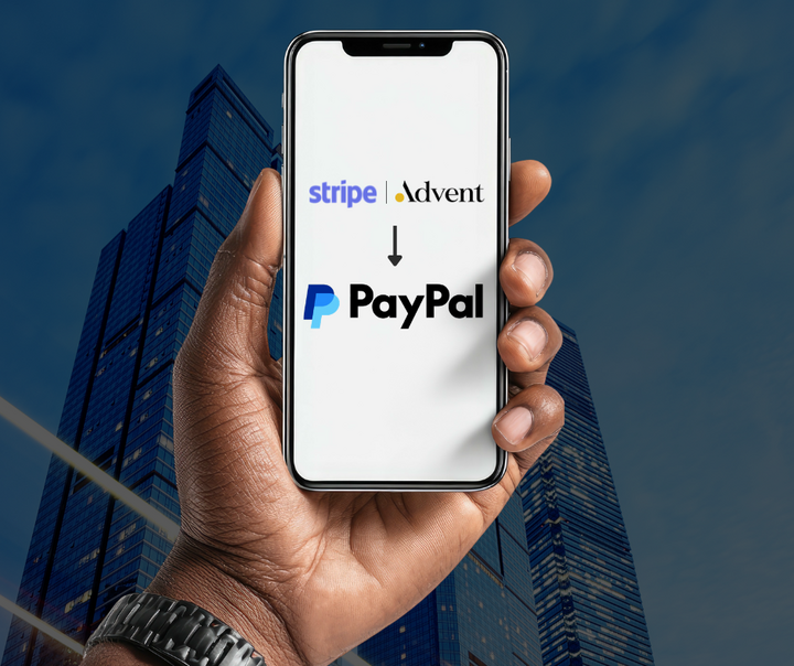 Hand holding smartphone displaying Stripe and Advent International acquisition offer pointing to PayPal logo with city skyline background